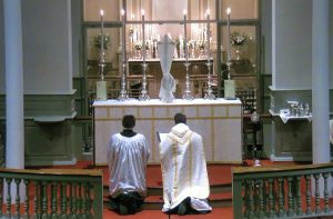 David Kennison and Fr. Matt kneeling before the altar